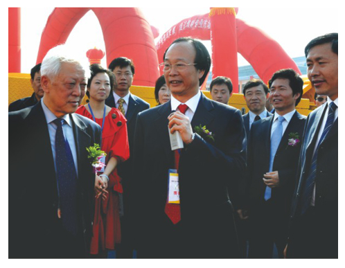 石華輝董事長為視察公司展位的全國人大副委員長周鐵農介紹產品技術特點